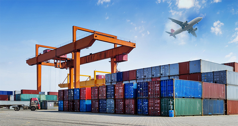 Cargo port with containers and an aircraft overhead